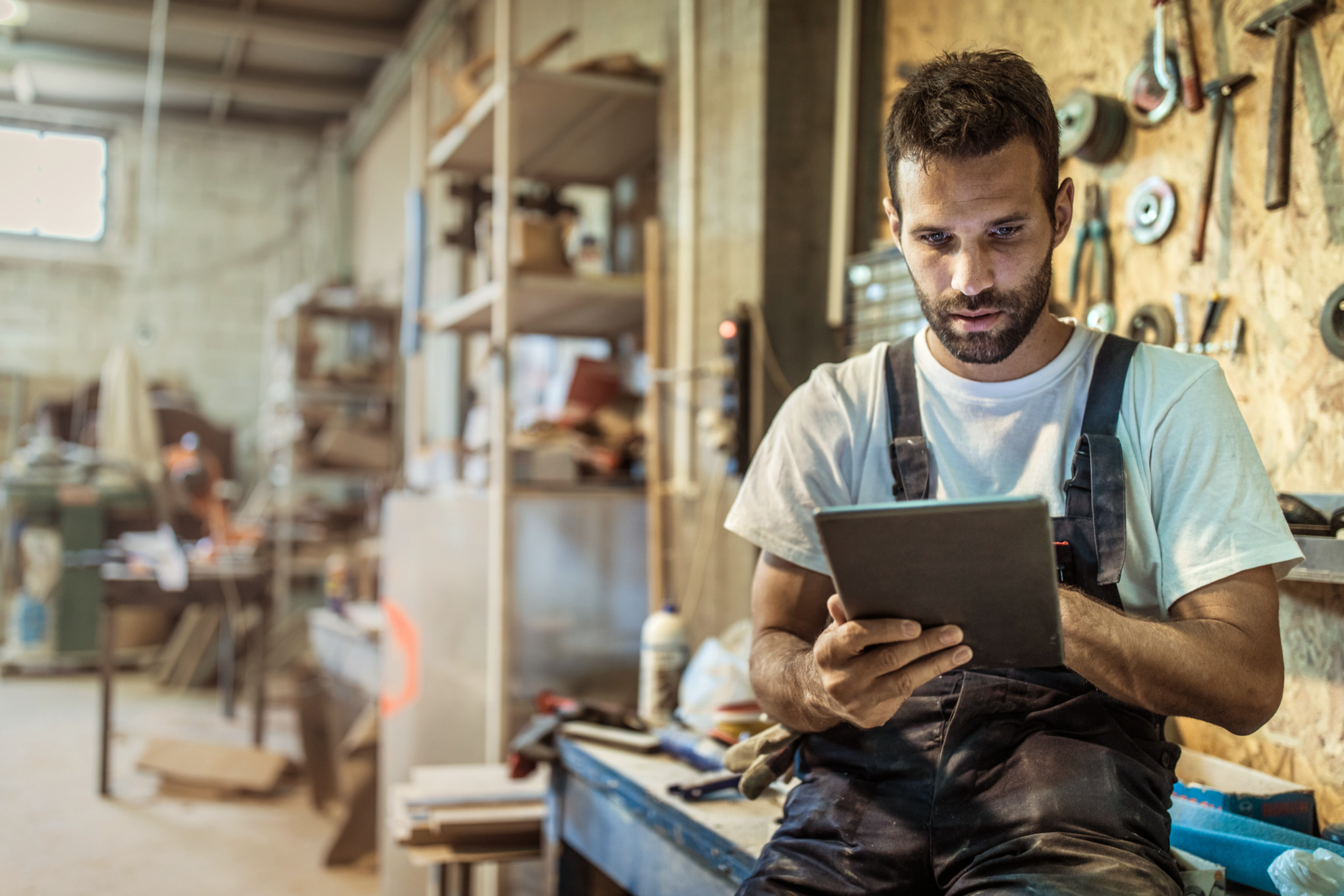 Hombre en un taller utiliza el asesor de productos STIHL en una tablet