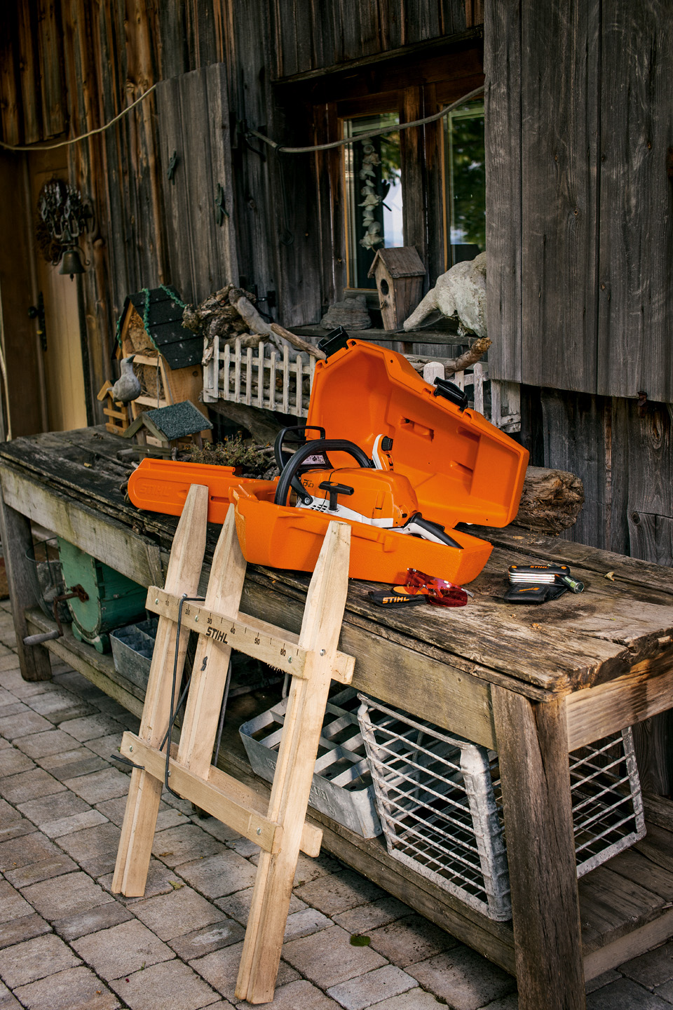 Una motosierra STIHL en una caja de almacenamiento de plástico sobre un banco de trabajo de madera
