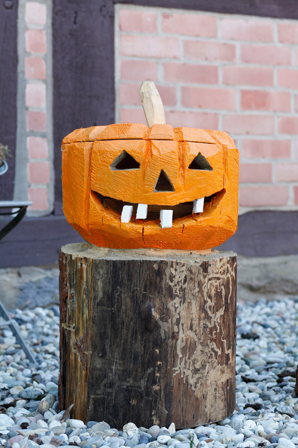decoración de Halloween para el jardín: una calabaza de madera pintada