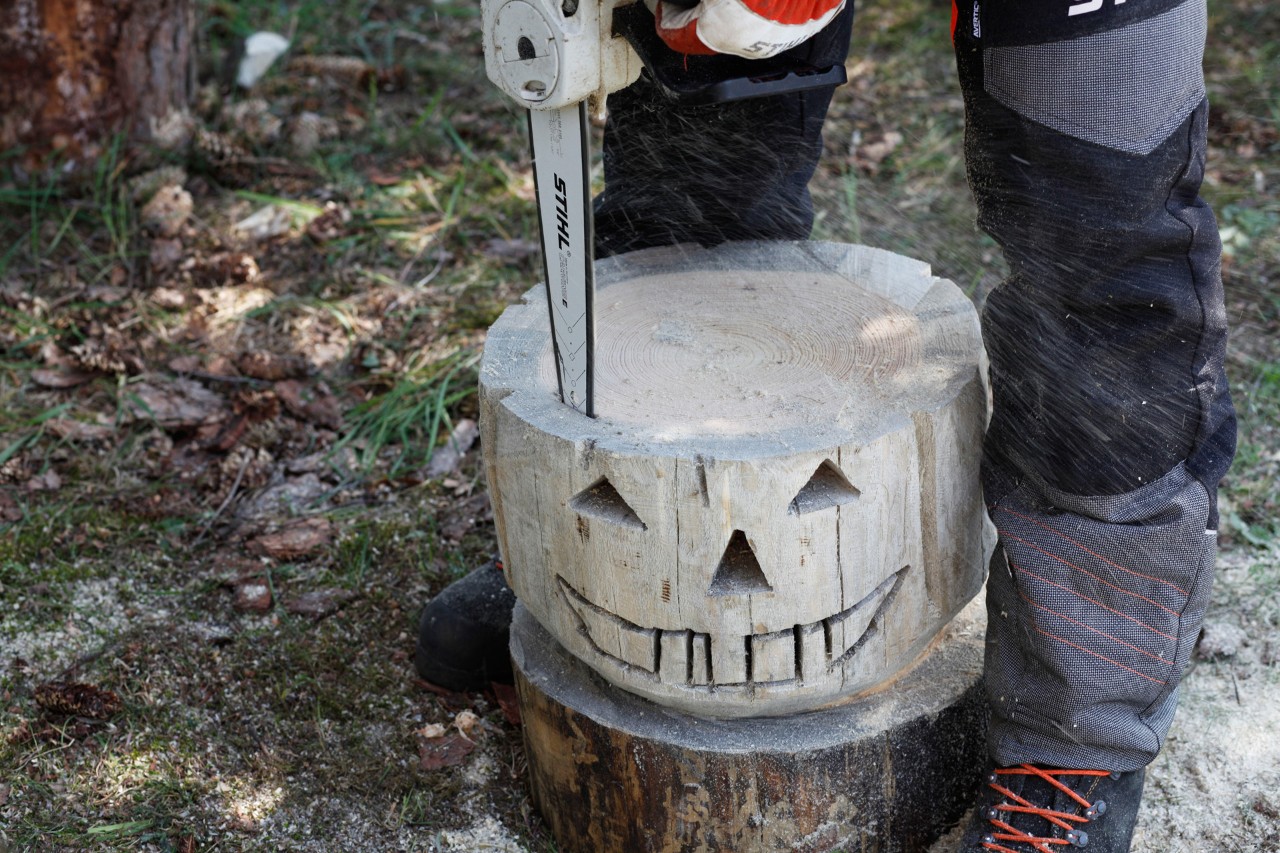 Una motosierra STIHL MSA 140 C utilizada para cortar el centro de una calabaza de madera.