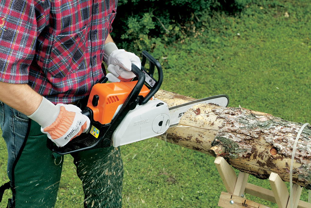 Corte de una pieza de tejado plano desde el centro del tronco con una motosierra STIHL para hacer una casa de pájaros.