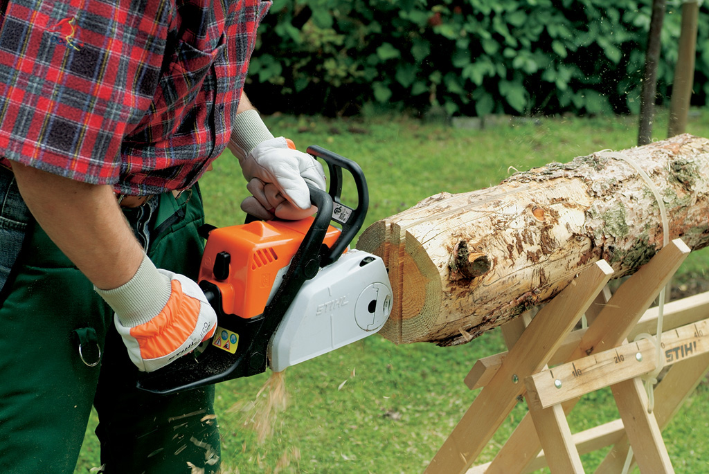 Corte de una pieza de tejado plano desde el centro del tronco con una motosierra STIHL para hacer una casa de pájaros.