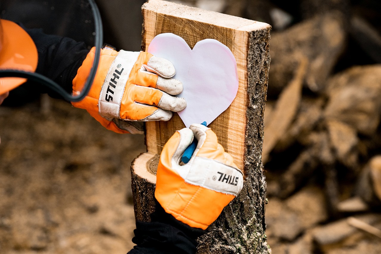 Cómo tallar un corazón de madera para decorar: una plantilla de cartón con forma de corazón en la cara plana de la madera dibujada con tiza