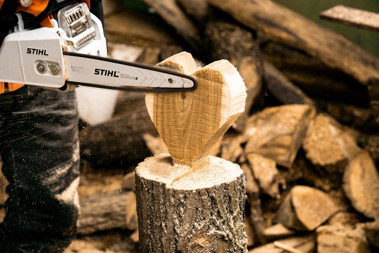 Cómo tallar un corazón de madera para decorar: alisando los bordes del corazón de madera con una motosierra de gasolina STIHL MS 170
