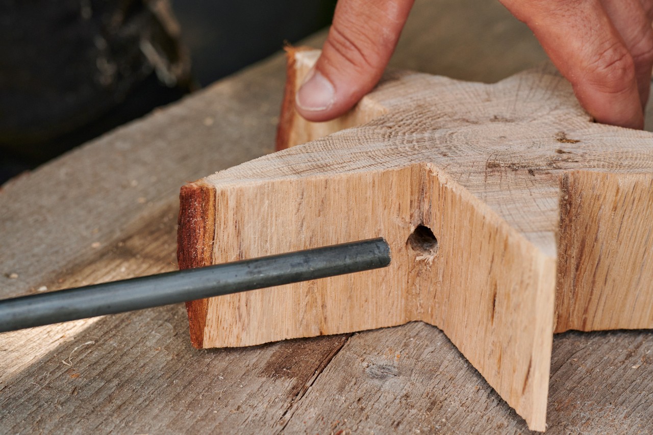 La varilla se introduce en el orificio de la estrella de madera