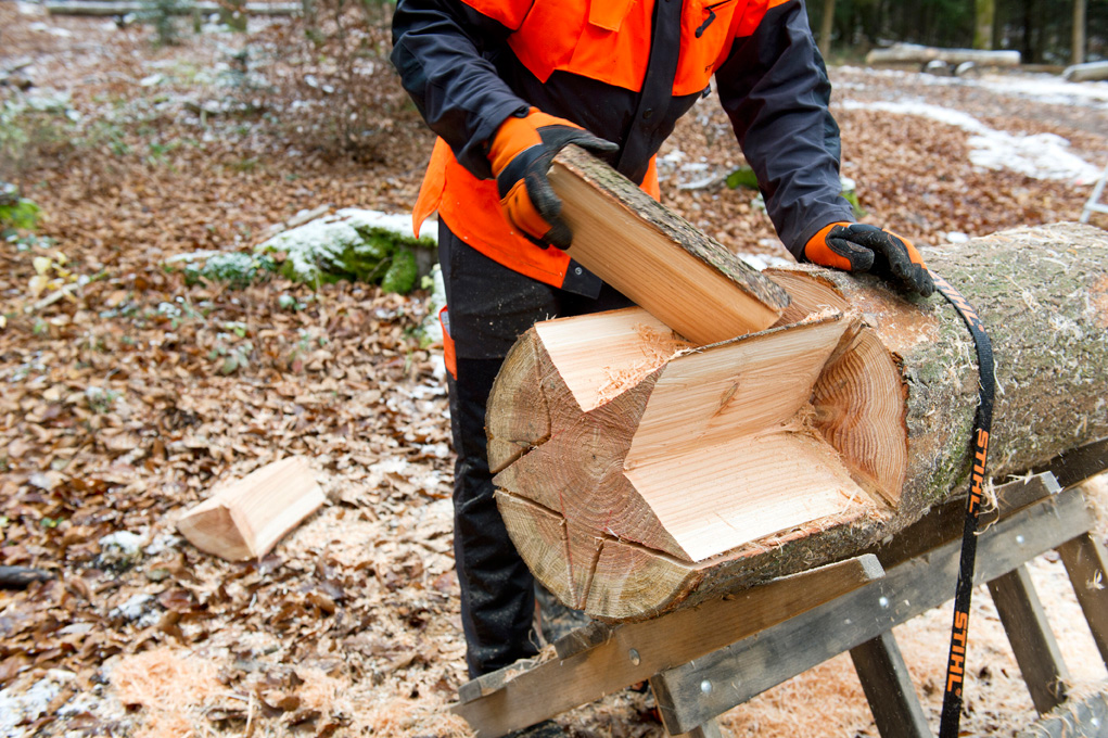 Haciendo una estrella de madera: una persona retira los trozos sobrantes de un tronco cortado en forma de estrella.