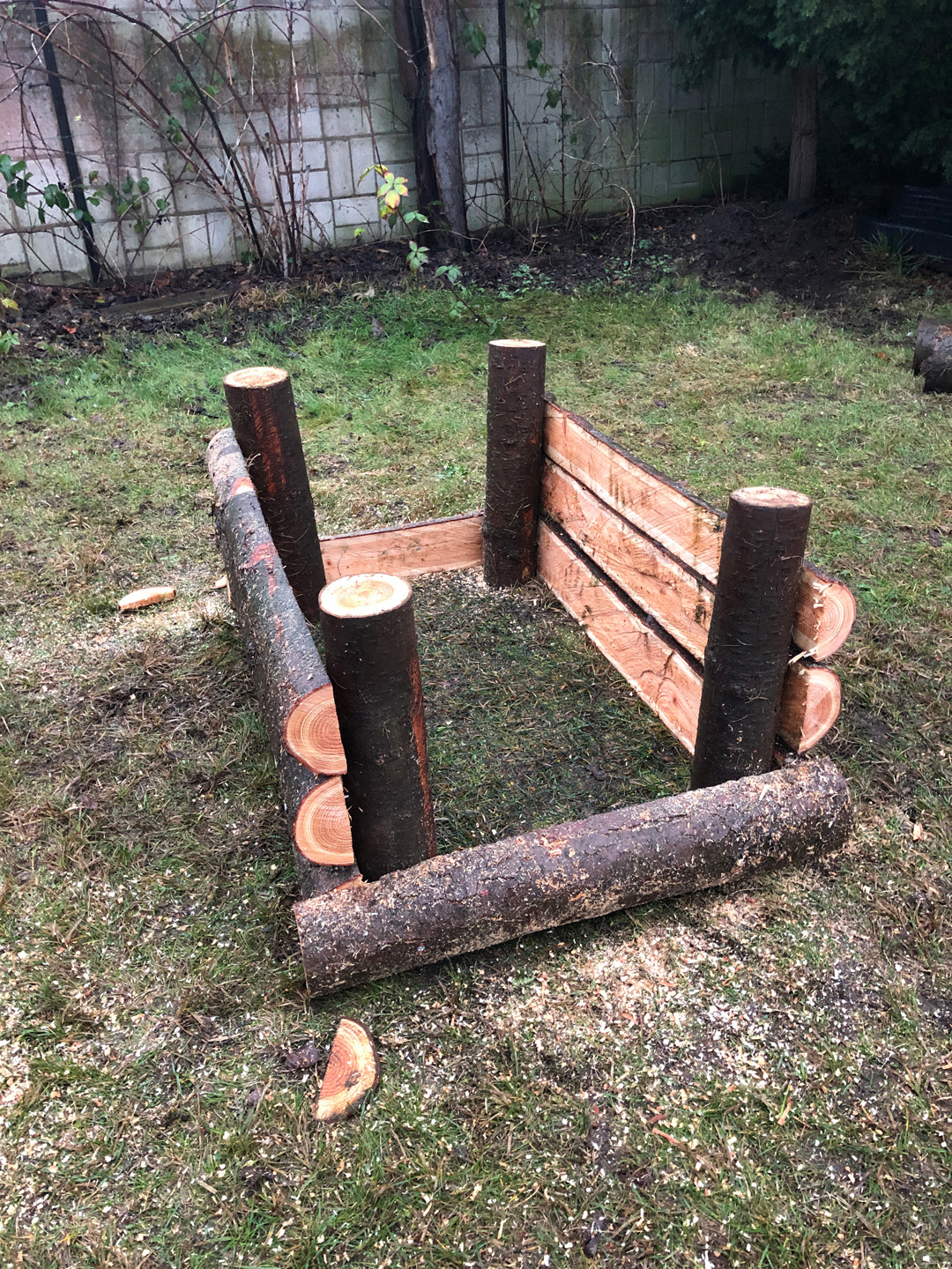 Construir una mesa de cultivo con materiales como troncos: paneles laterales sujetos a los cuatro postes.