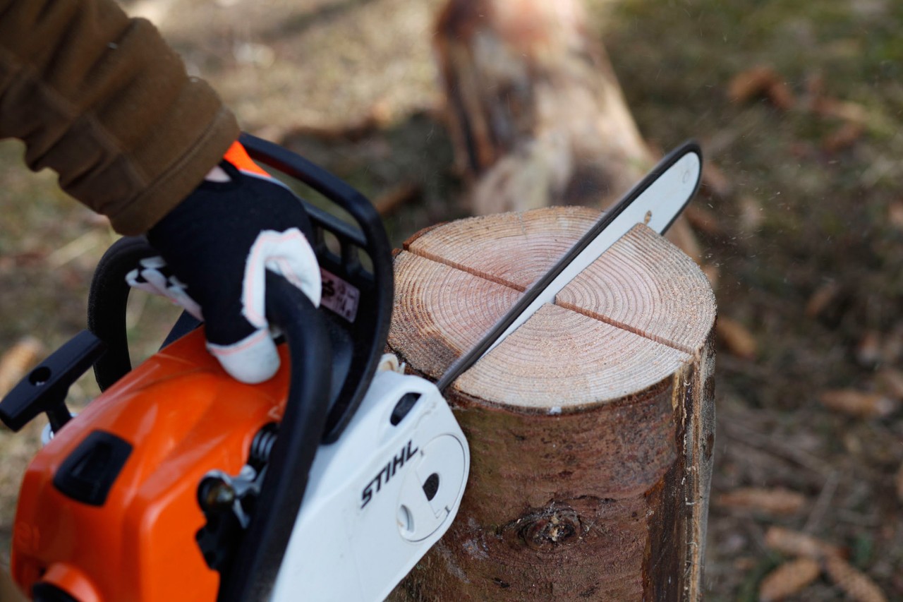 Motosierra de gasolina STIHL MS 181 C realizando dos cortes en un tronco vertical