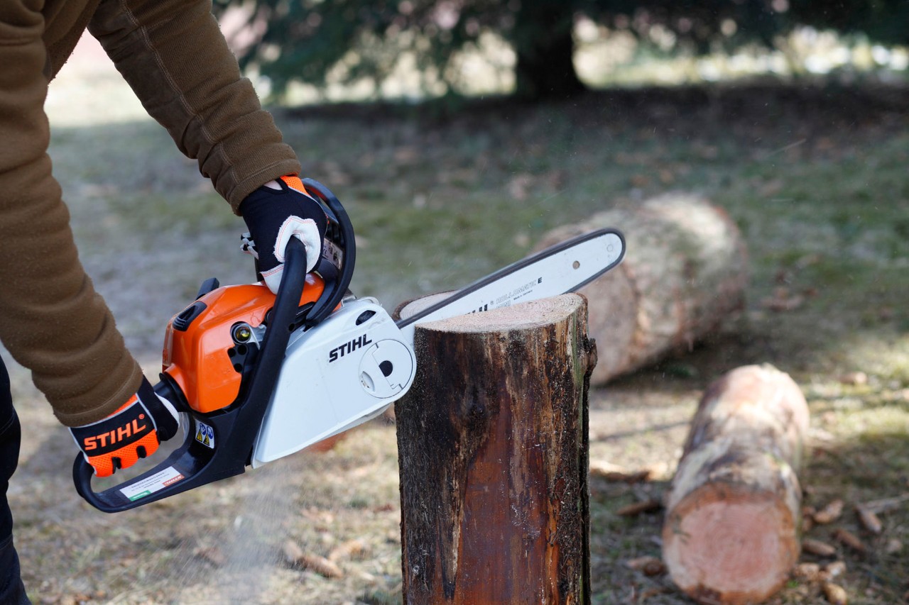 Motosierra de gasolina STIHL MS 181 C realizando dos cortes en un tronco vertical.
