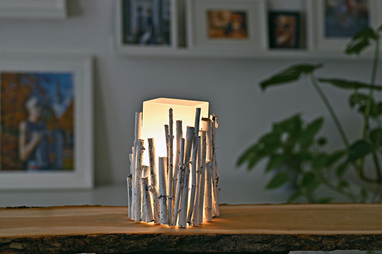 Decora tu mesa con una lámpara de ramas pequeñas: una lámpara terminada y encendida sobre una mesa.