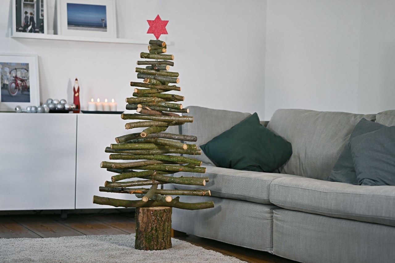 Árbol de Navidad hecho a mano en madera en un interior decorado con adornos navideños