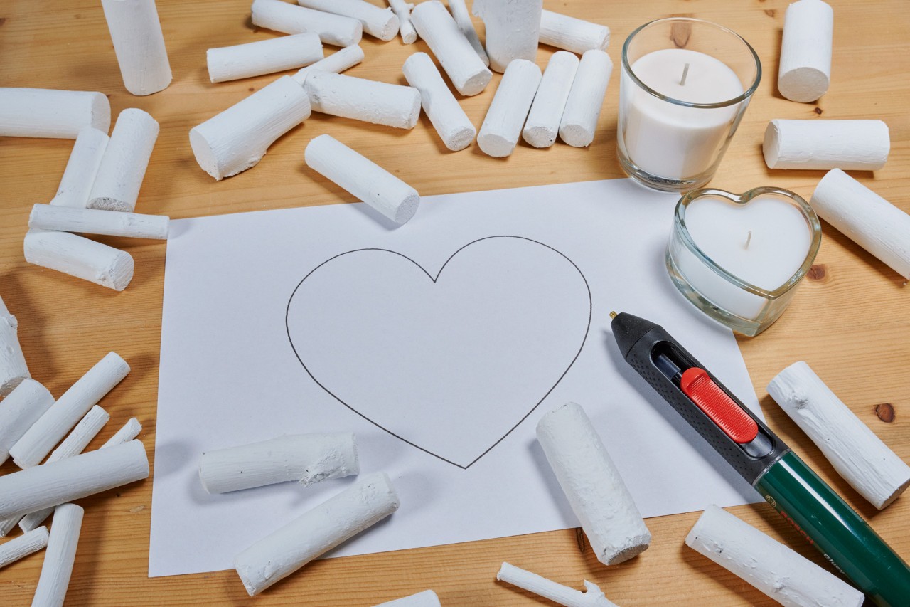 Crear un corazón de ramas: una forma de corazón en un trozo de papel y ramas pintadas distribuidas a su alrededor.