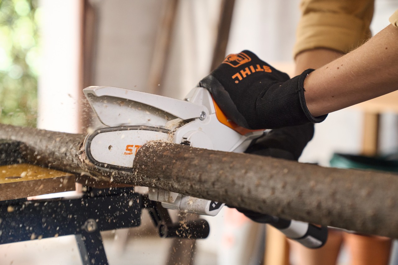 Primer plano de una persona cortando una rama a medida con la herramienta de poda STIHL GTA 26