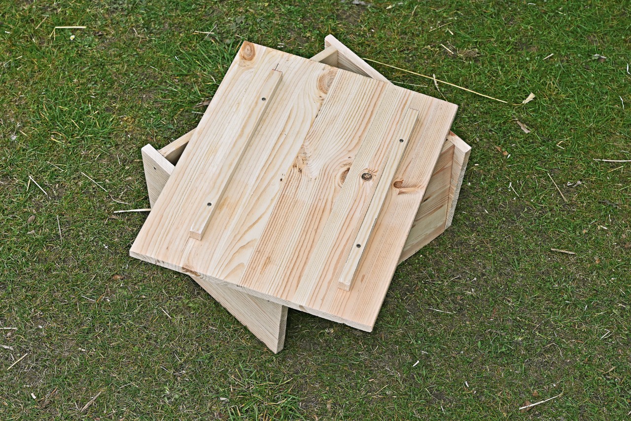 Una placa para el techo sin colocar con listones de madera sobre una casa de madera para erizos.