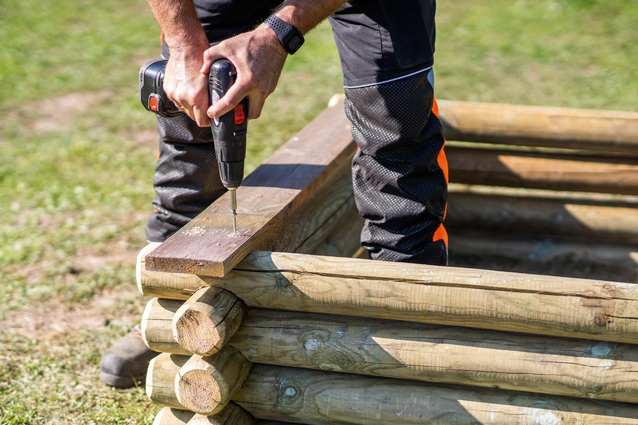 Uno de los bancos del cajón de arena artesanal atornillado al tronco superior realizado con STIHL.
