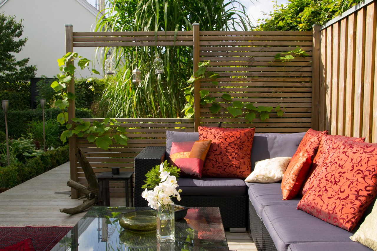 Moderna terraza con sofá y pantalla de privacidad de madera 