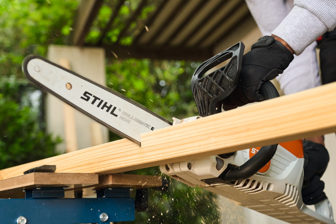 Un hombre corta a medida un tirante lateral para una portería de fútbol con una STIHL MSA 70