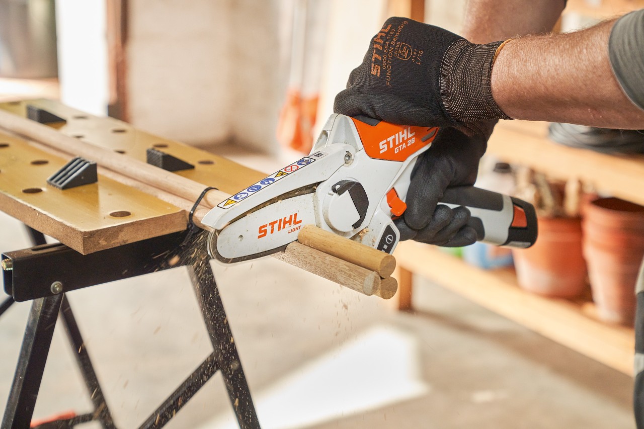 Un hombre corta barras redondas con la minisierra de batería STIHL GTA 26