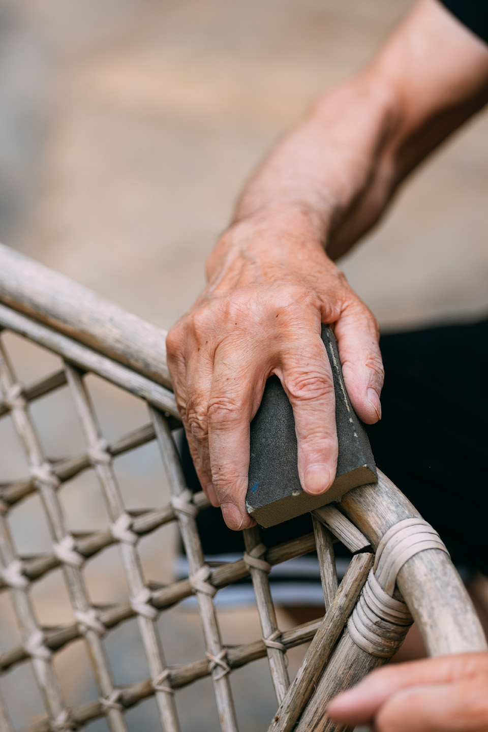 Mantenimiento muebles de rattan: primer plano del pulido de una silla de jardín de caña. 