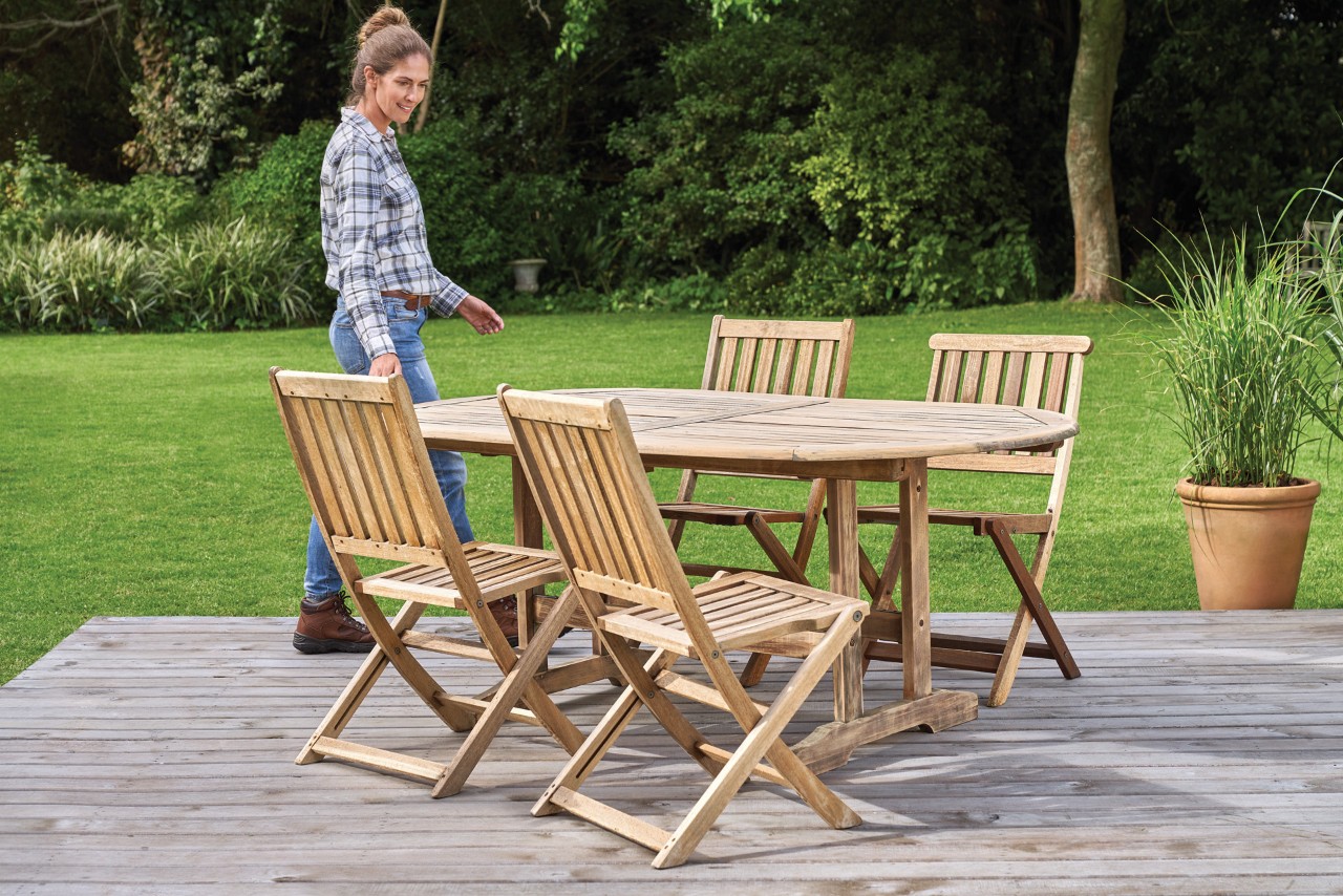  Cómo proteger muebles de madera para exterior: una mujer inspecciona un patio con una hidrolimpiadora STIHL RE 130 Plus.