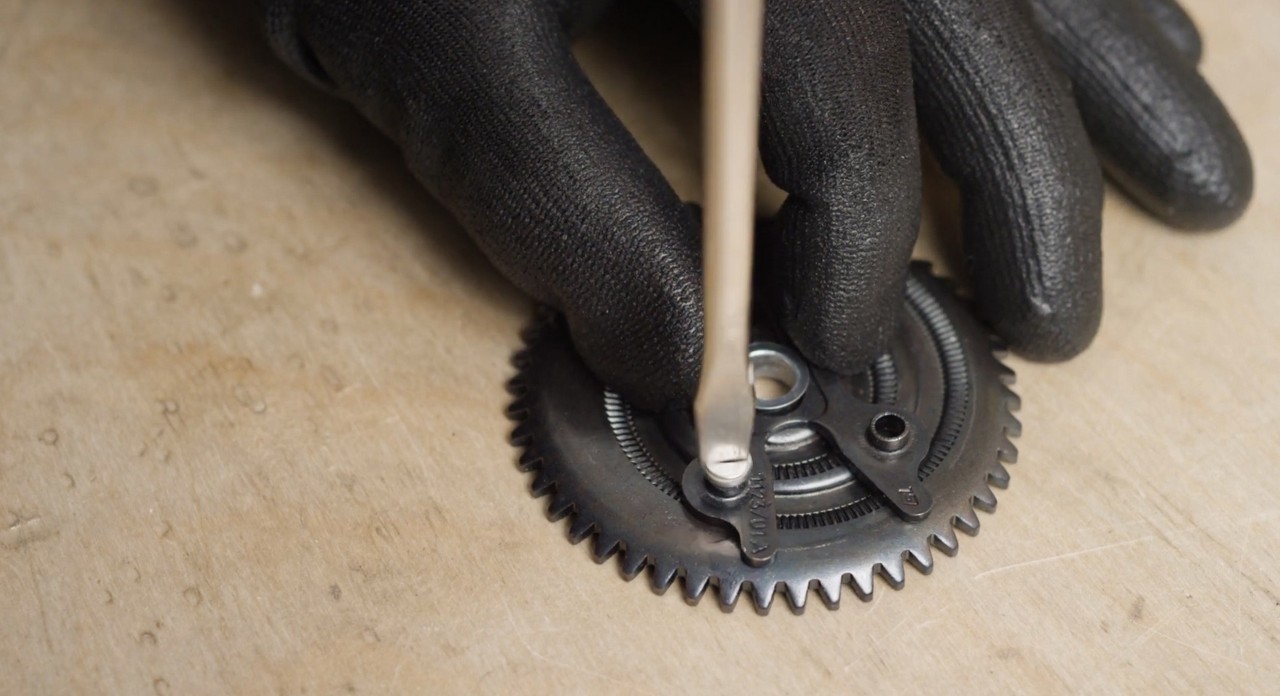 Primer plano de la rueda tensora al cambiar una cadena de motosierra