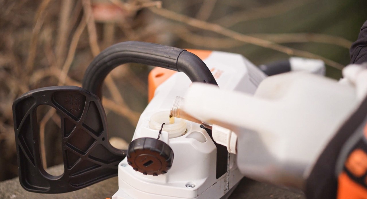 Llenado de una motosierra STIHL de batería MSA 120 con aceite para cadena