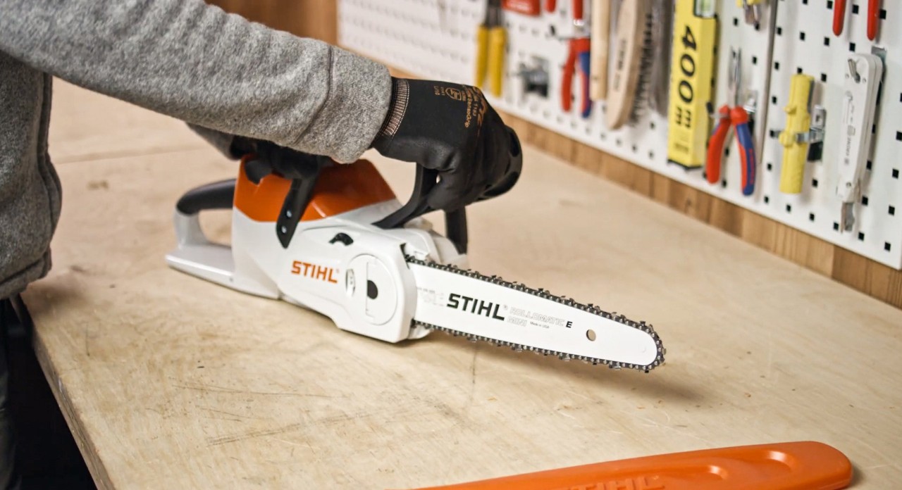 Alguien revisa, en un banco de trabajo, una motosierra STIHL de batería MSA 120 