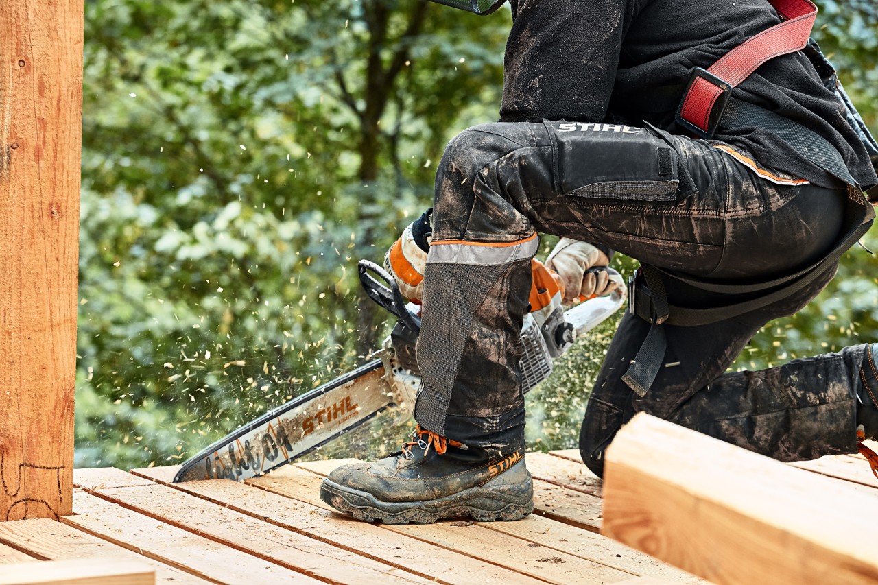 Una persona protegida con pantalones anticorte STIHL ADVANCE X-LIGHT usa una motosierra STIHL MS 261