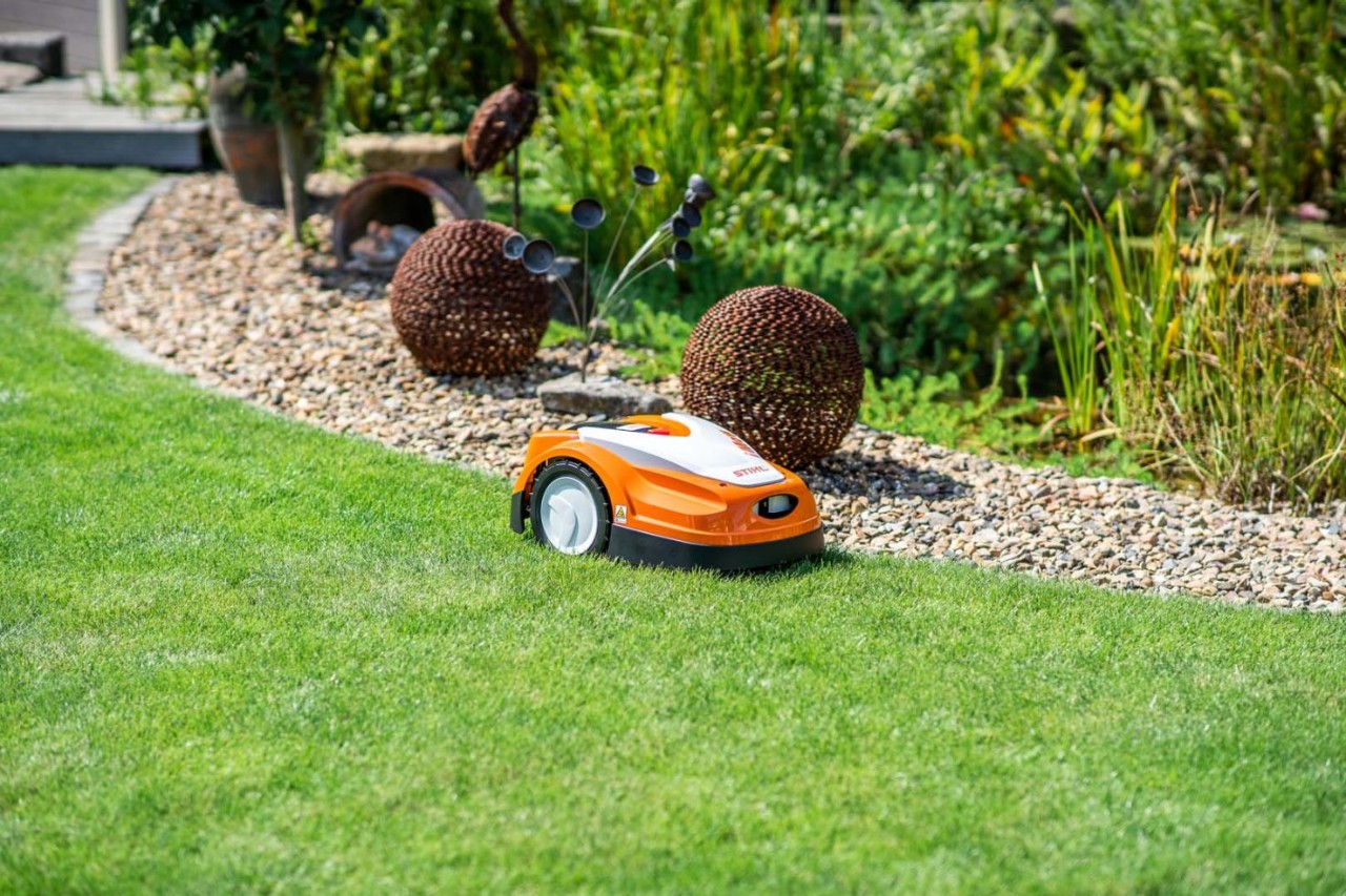 Un robot cortacésped STIHL iMOW® 422 sobre el césped verde antes del mantenimiento