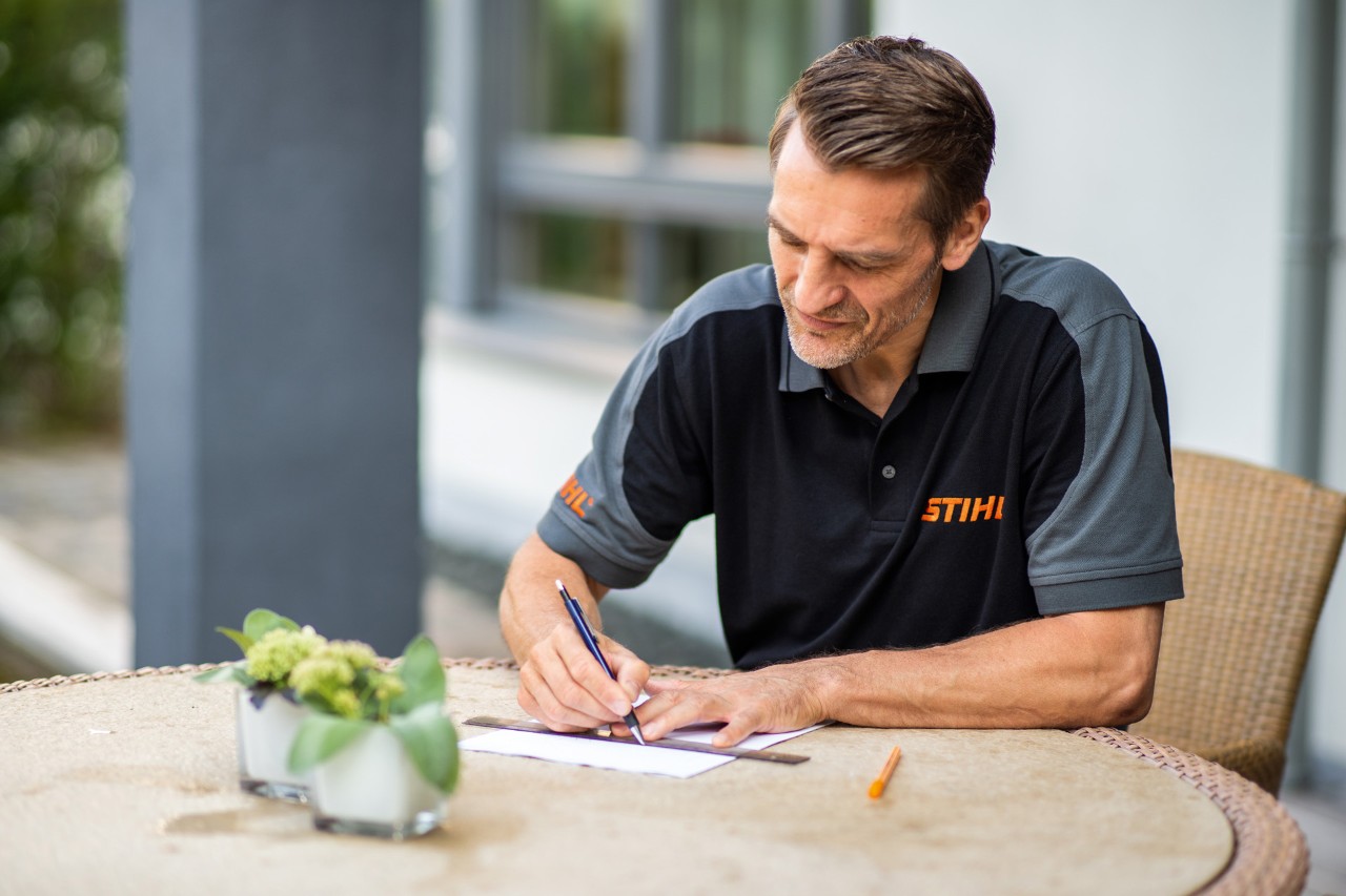Un distribuidor STIHL dibujando el área de corte para un robot cortacésped STIHL iMOW® 422