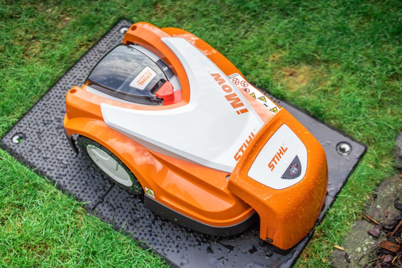 Un robot cortacésped STIHL RMI 422 iMOW® en su estación de carga