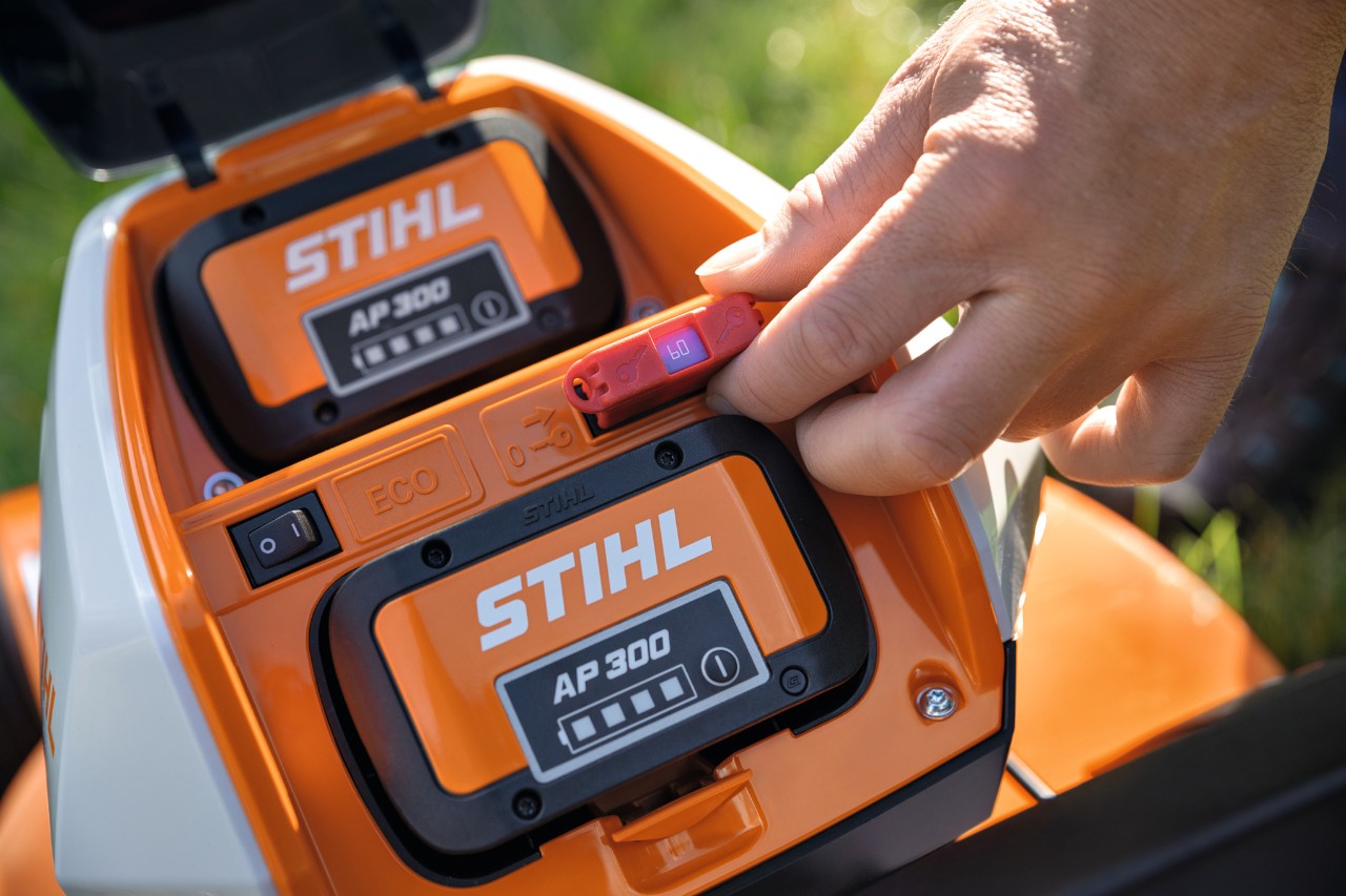 Una persona inserta un conector de seguridad en el cortacésped de batería STIHL RMA 448 VC 