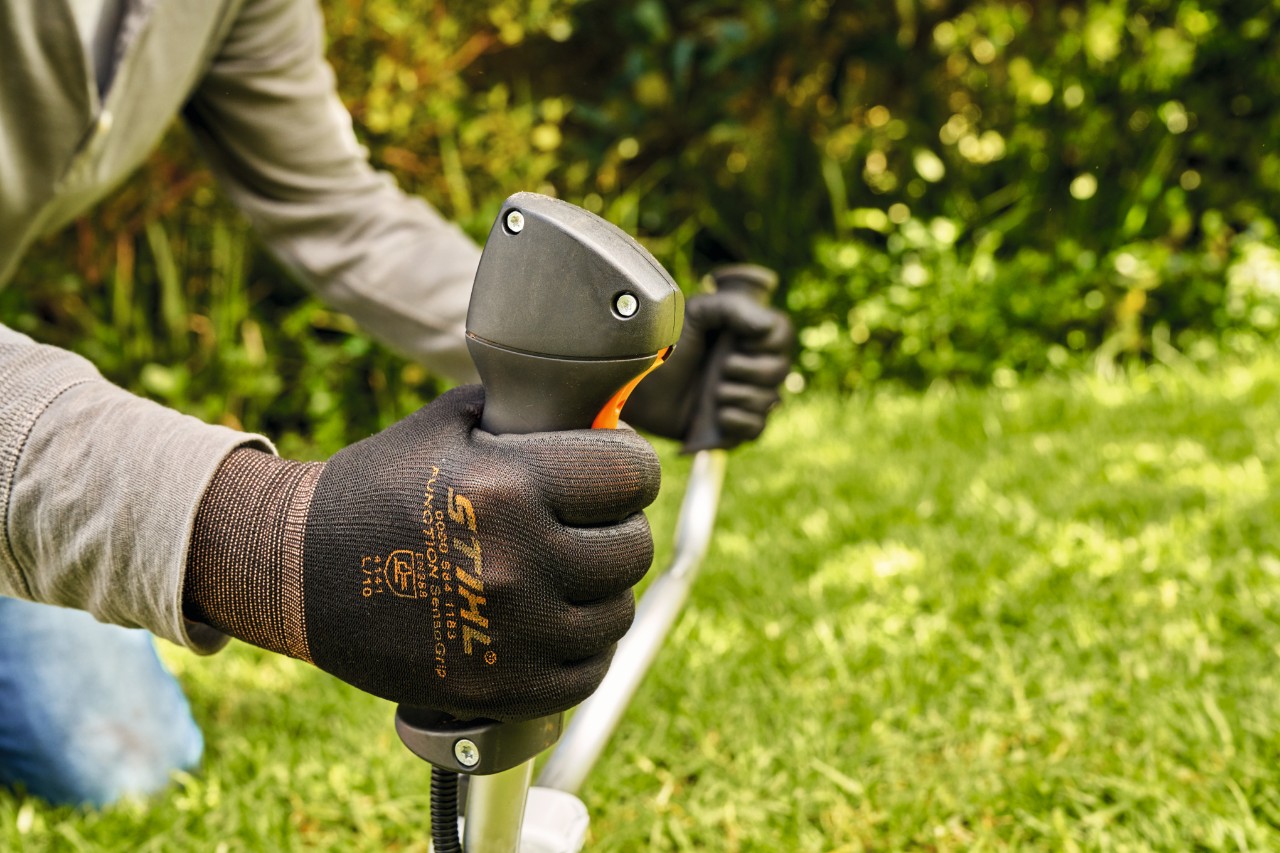 Un hombre arranca brevemente el motor de la desbrozadora de gasolina STIHL FS 91