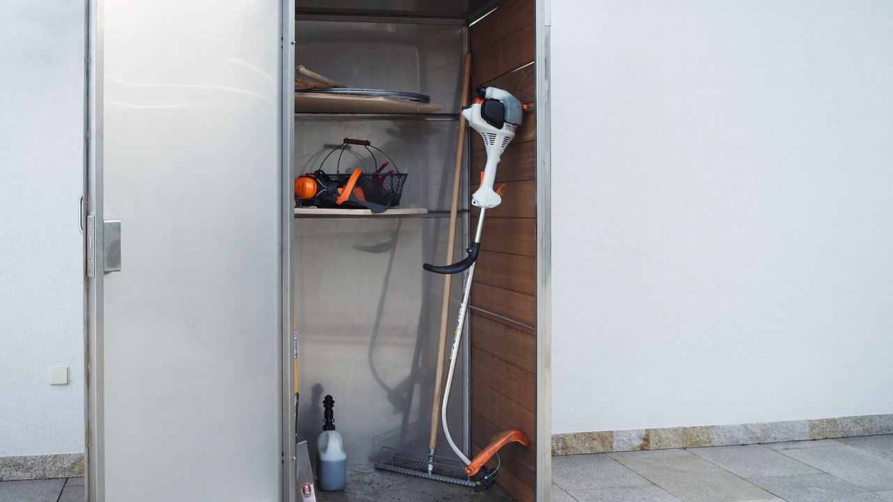 La desbrozadora de gasolina STIHL FS 38 apagada se guarda en un armario