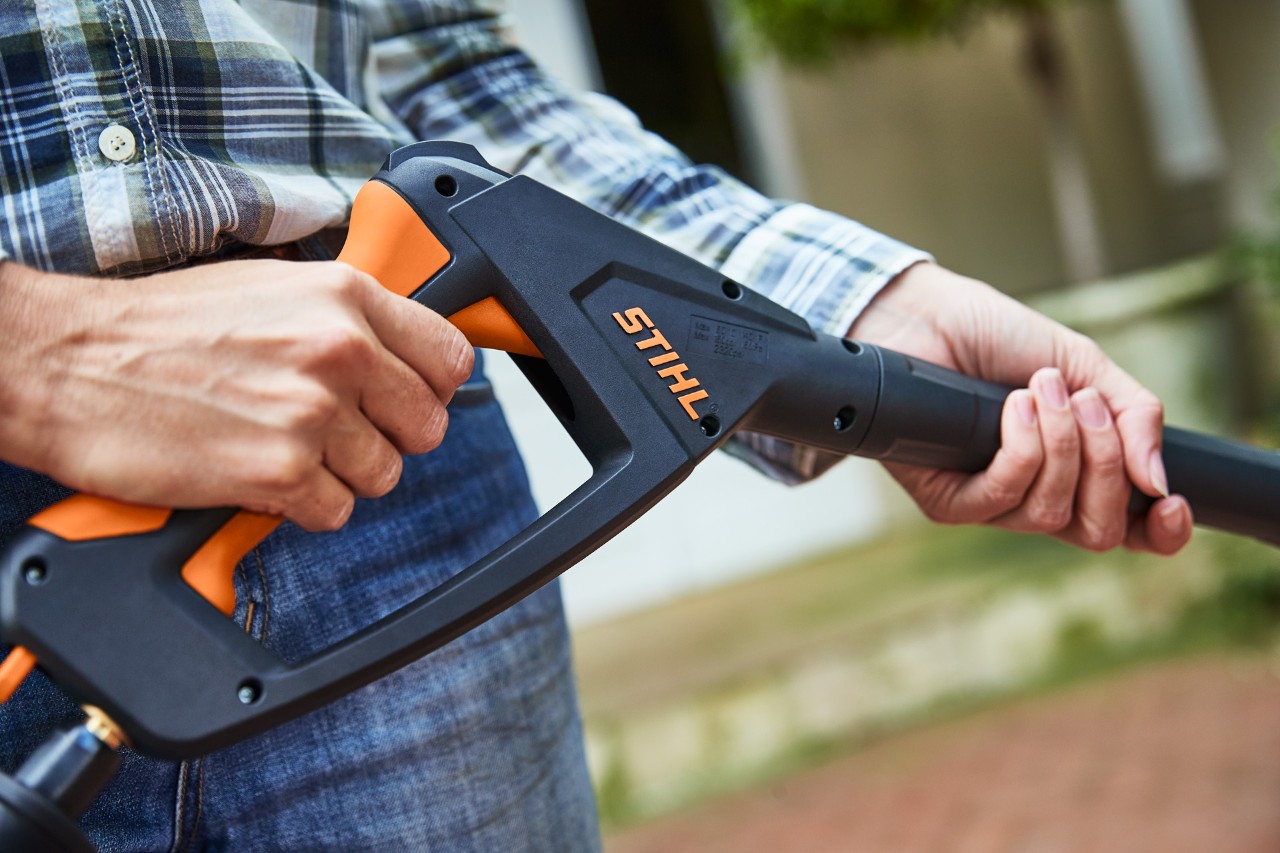 Una persona acciona la pistola de la hidrolimpiadora STIHL RE 130 PLUS estando apagada