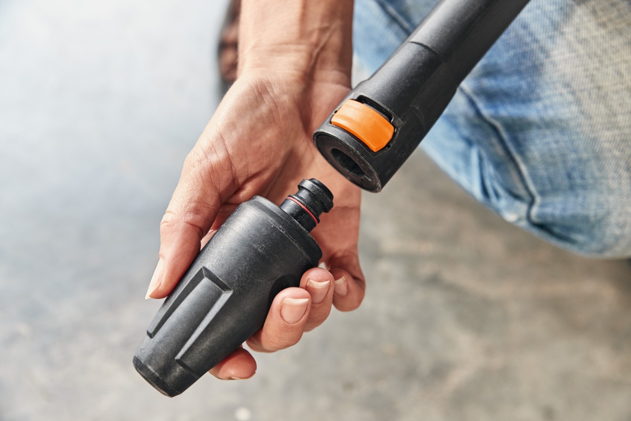  Una persona monta un accesorio en la hidrolimpiadora STIHL RE 130 PLUS