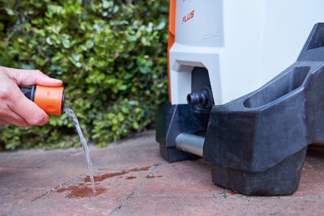 Una persona limpia el filtro de entrada de agua de la hidrolimpiadora STIHL RE 130 PLUS para su mantenimiento.