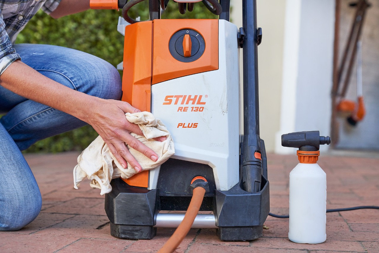 Una mujer aplica anticogelante a una hidrolimpiadora STIHL RE 130 PLUS antes de guardarla.