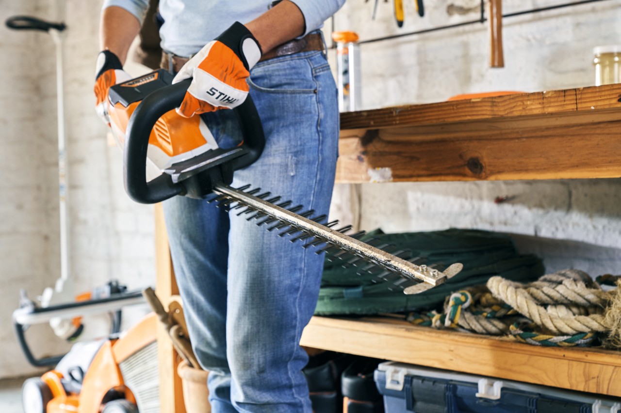 Una mujer sujeta un cortasetos de batería STIHL HSA 56