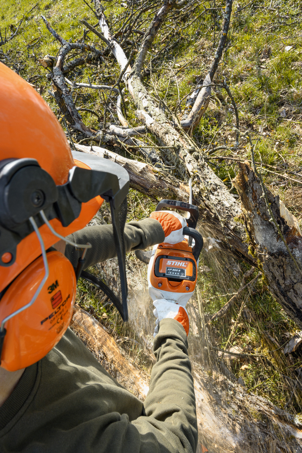 Una motosierra de batería STIHL MSA 220 C-B utilizada por un operador con guantes para desramar un árbol