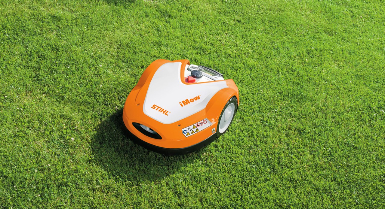 Un robot cortacésped STIHL iMOW® RMI 632 con función trituradora en un césped nuevo muy verde.