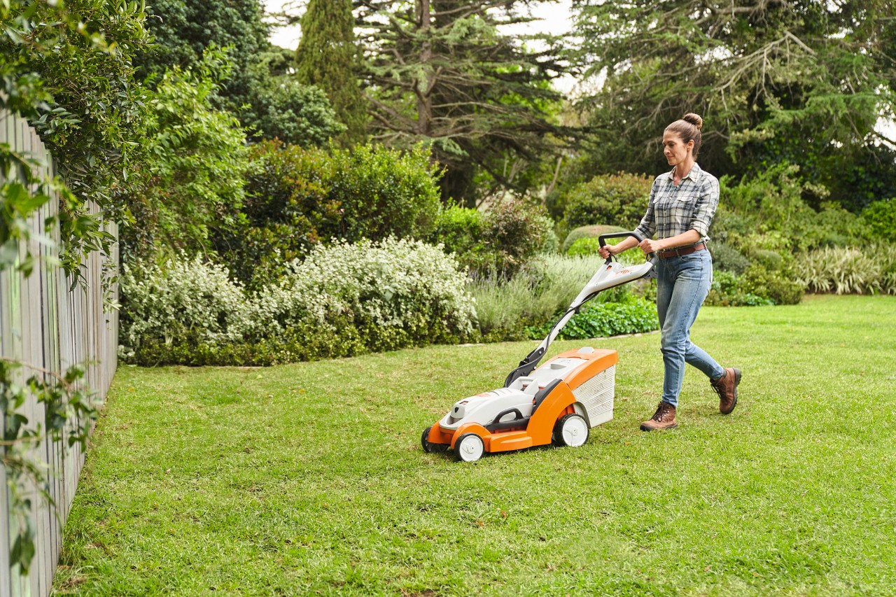 Una mujer corta el césped con un cortacésped de batería STIHL RMA 339 C
