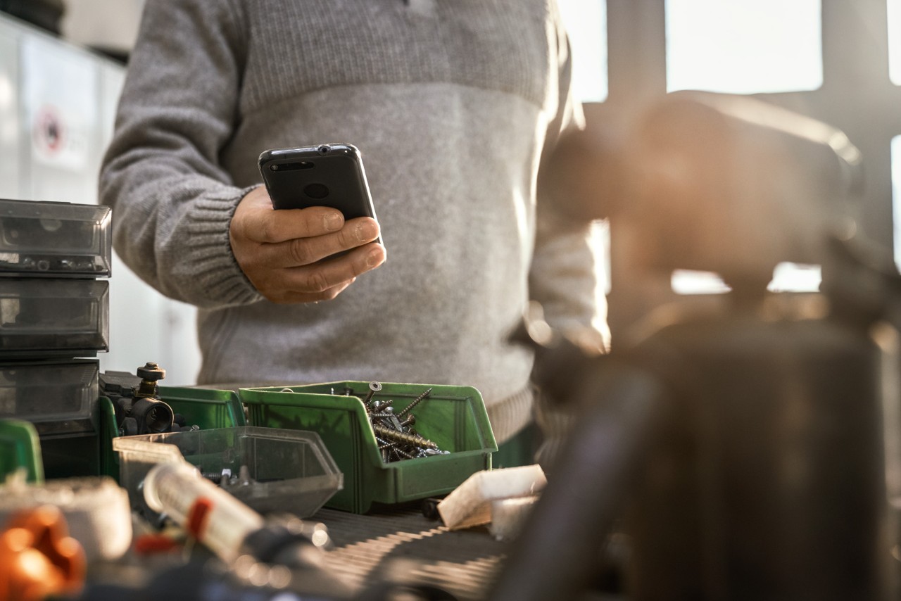 Una persona con un smartphone en un taller