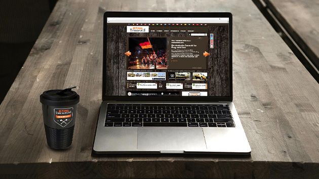 Portátil con el sitio web de Timbersports abierto y una taza de café de Timbersports