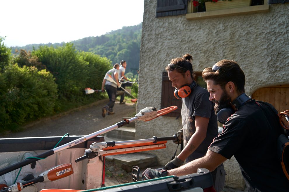 Dos trabajadores de una empresa de jardinería cogen máquinas de jardín STIHL para trabajar