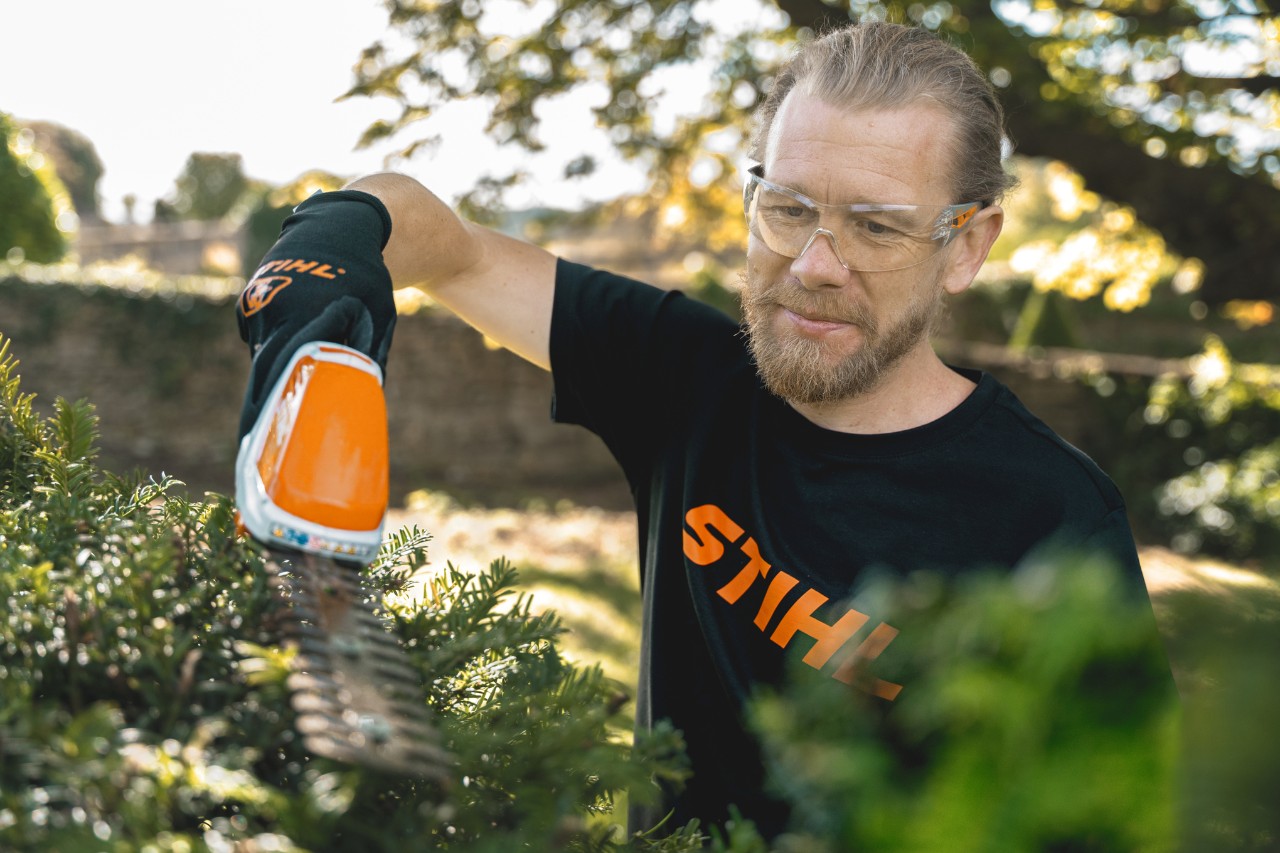 El jardinero jefe Andrew Wain corta un seto con un cortasetos de batería STIHL