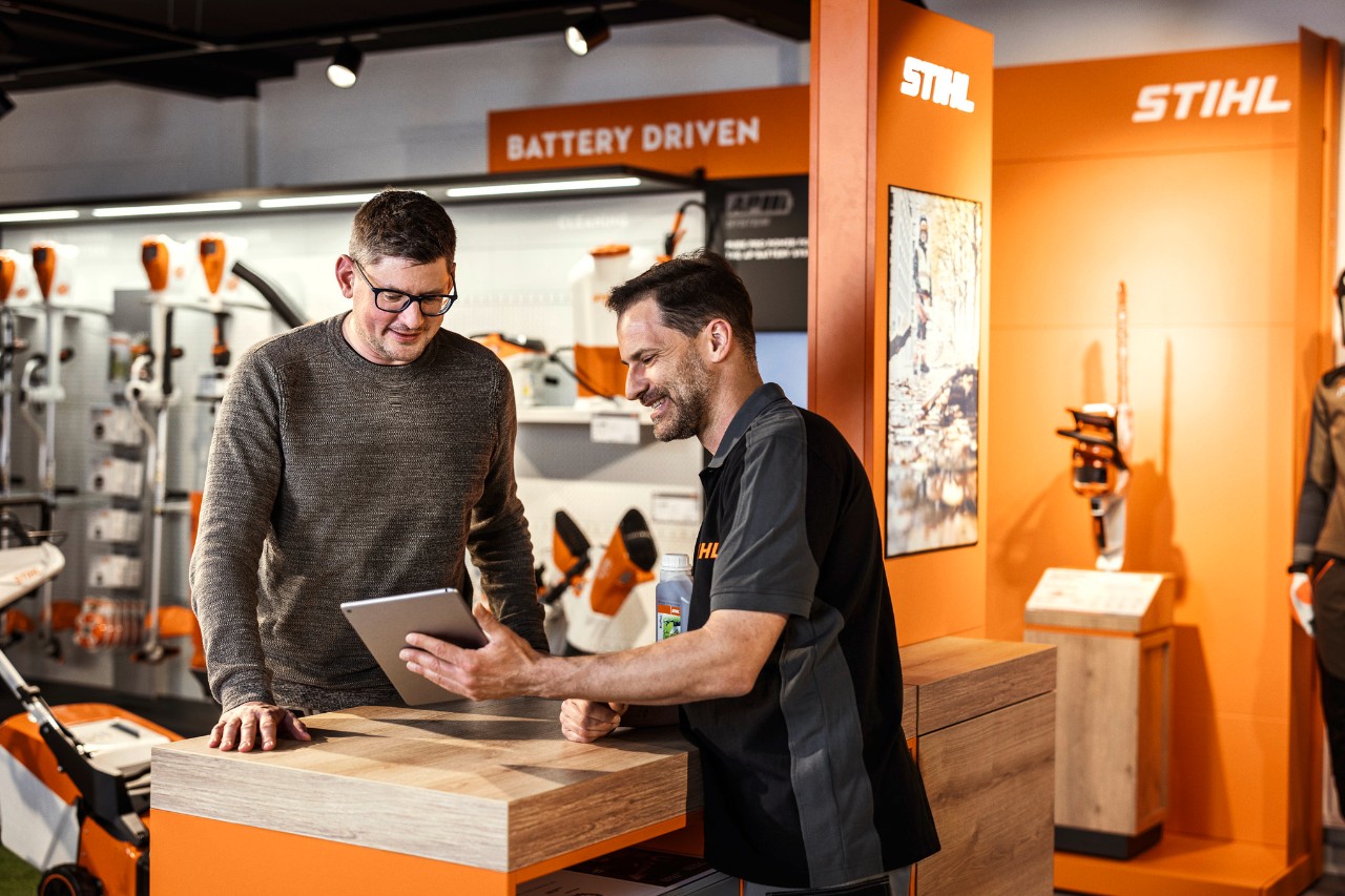 Un distribuidor de STIHL asesora a un cliente en una sala de exposición.